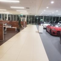 inside of a car dealership with parked cars and desk space
